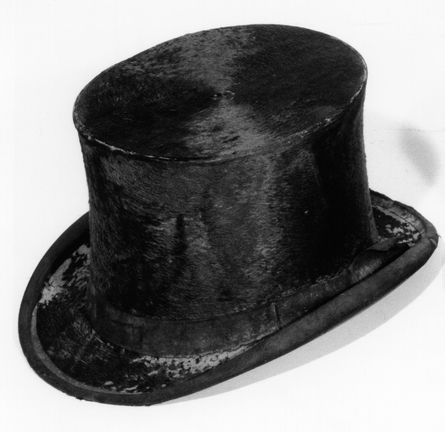 A color photo of a black top hat made from beaver fur. It looks shiny.