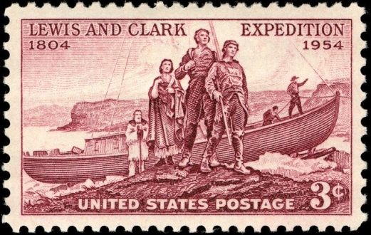 This stamp has text and a drawing printed in dark red ink. It reads, "Lewis and Clark Expedition 1804 1954. United States Postage 3¢". The drawing is of Lewis and Clark as well as Sacagawea and Toussaint Charbonneau standing by a boat. Additional people are visible inside the boat.